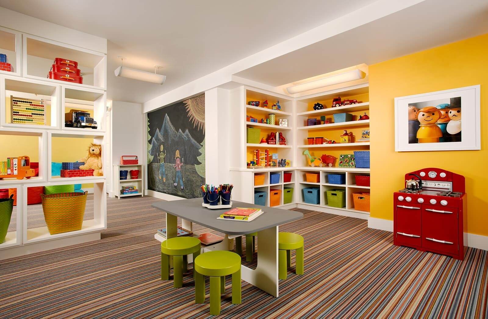 An organised toy storage area features open bins with picture labels positioned at child height, making it easy for kids to access their toys. This smart storage solution is perfect for toddler room ideas, promoting fun and imaginative play while keeping the space tidy.