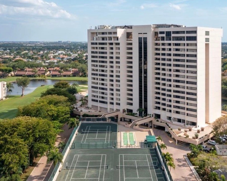 The image showcases a scenic view of McGregor Boulevard lined with palm trees, leading to the elegant entrance gates of The Landings, a gated community in Fort Myers, Florida. This picturesque setting highlights the lush landscape and inviting atmosphere of the Landings community, known for its various amenities and lifestyle options.