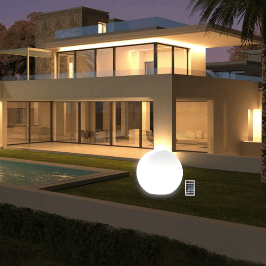 Modern house with large glass windows illuminated at night, featuring a glowing spherical outdoor light placed beside the swimming pool.