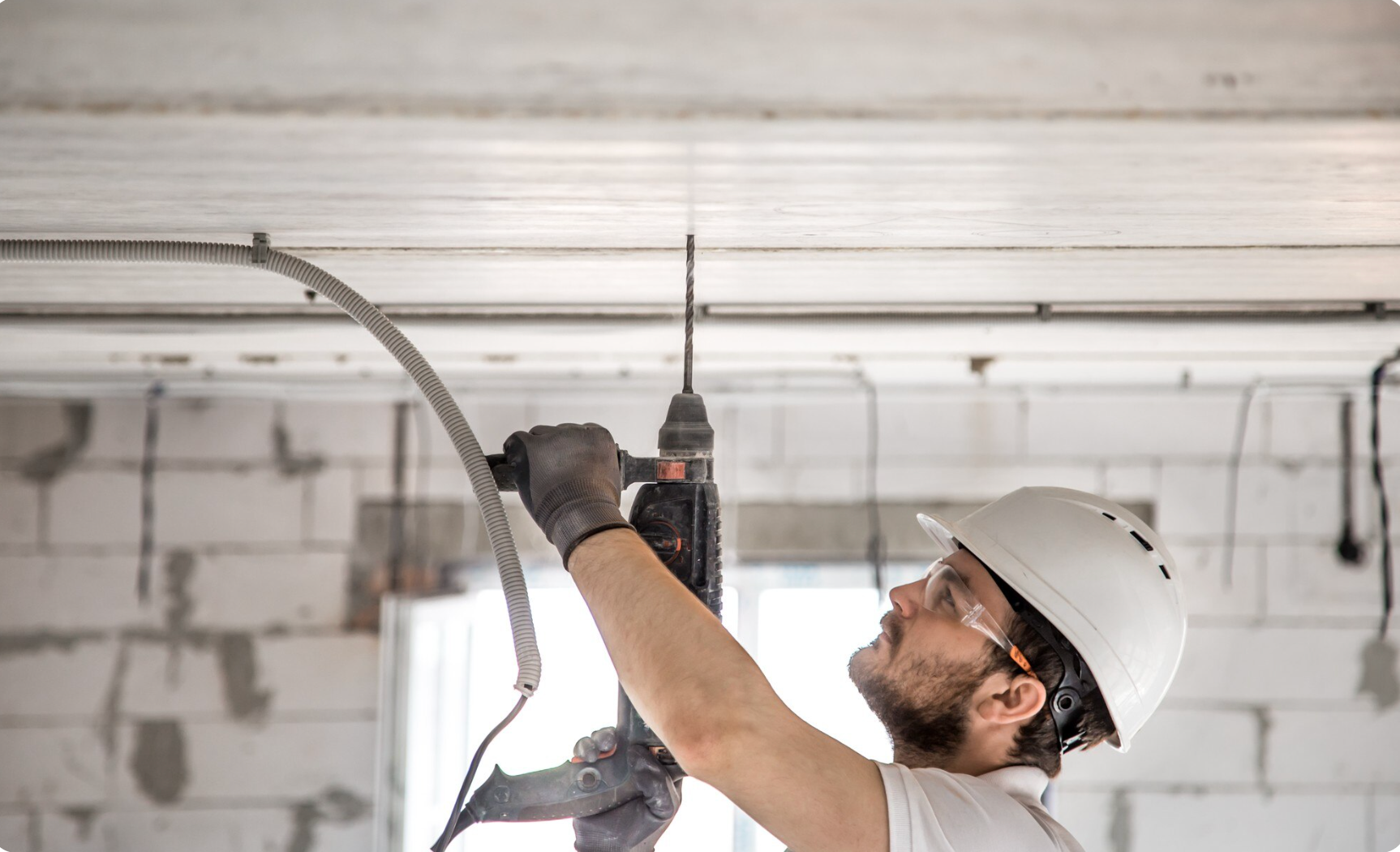 An electrician using jackhammer for installation - https://www.freepik.com/free-photo/handyman-uses-jackhammer-installation_10489143.htm#fromView=search&page=1&position=20&uuid=e8b7950d-a279-4433-8337-6fb3ebe61d4f&query=technician+ceiling