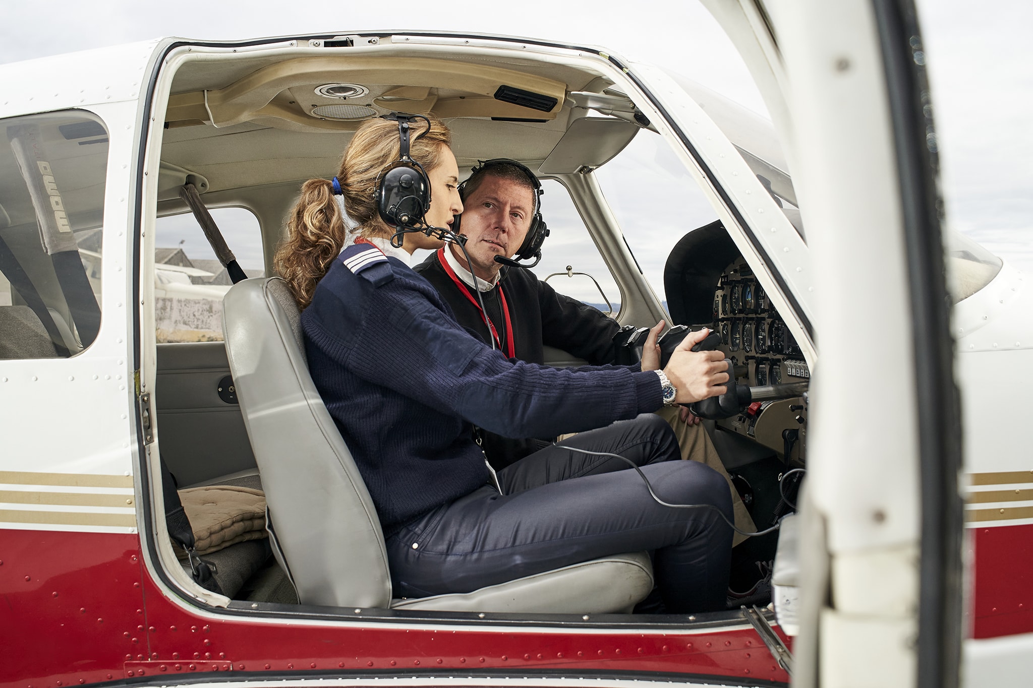 A flight instructor guiding a student pilot during training