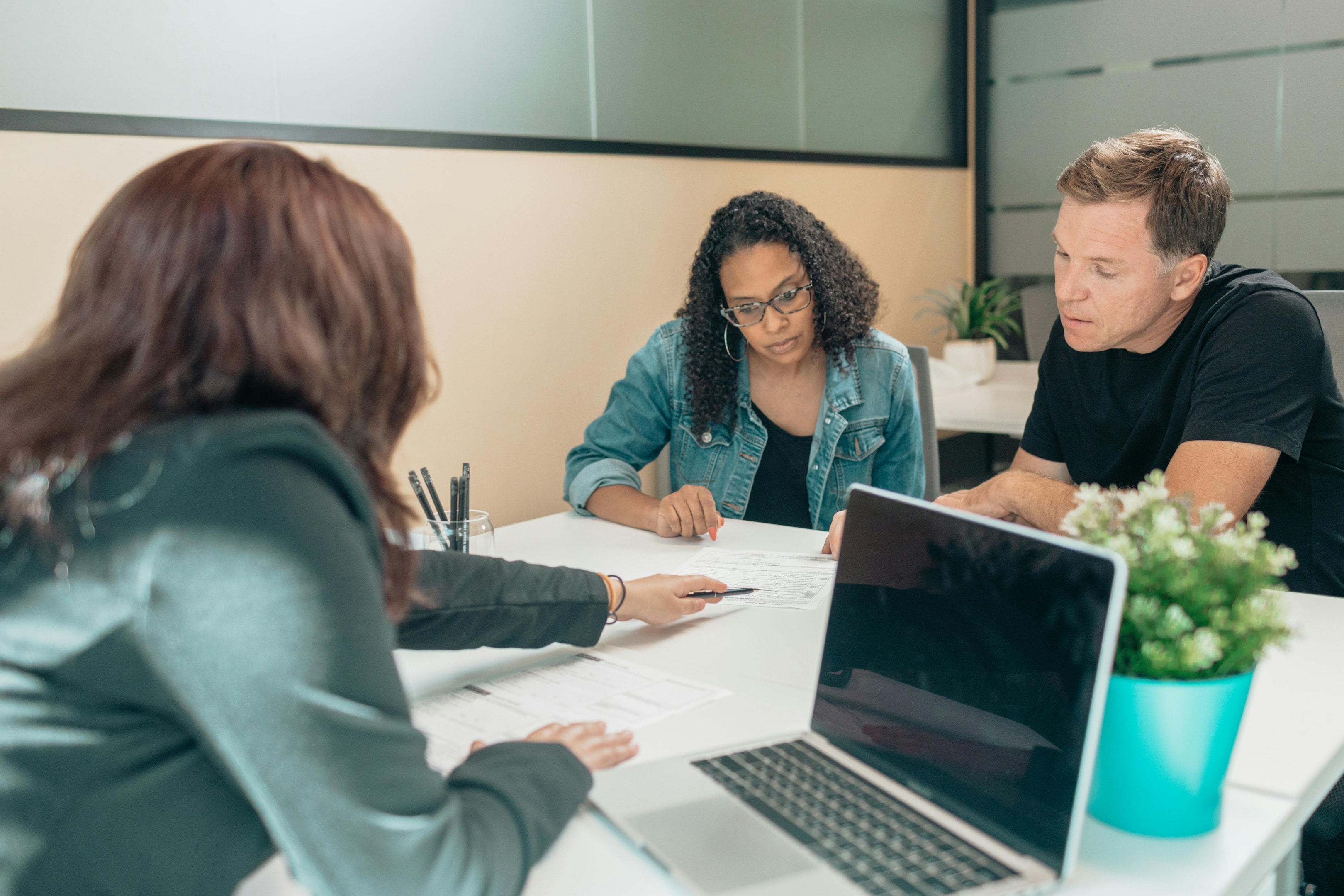 Real estate agent signs closing paperwork with investors. 