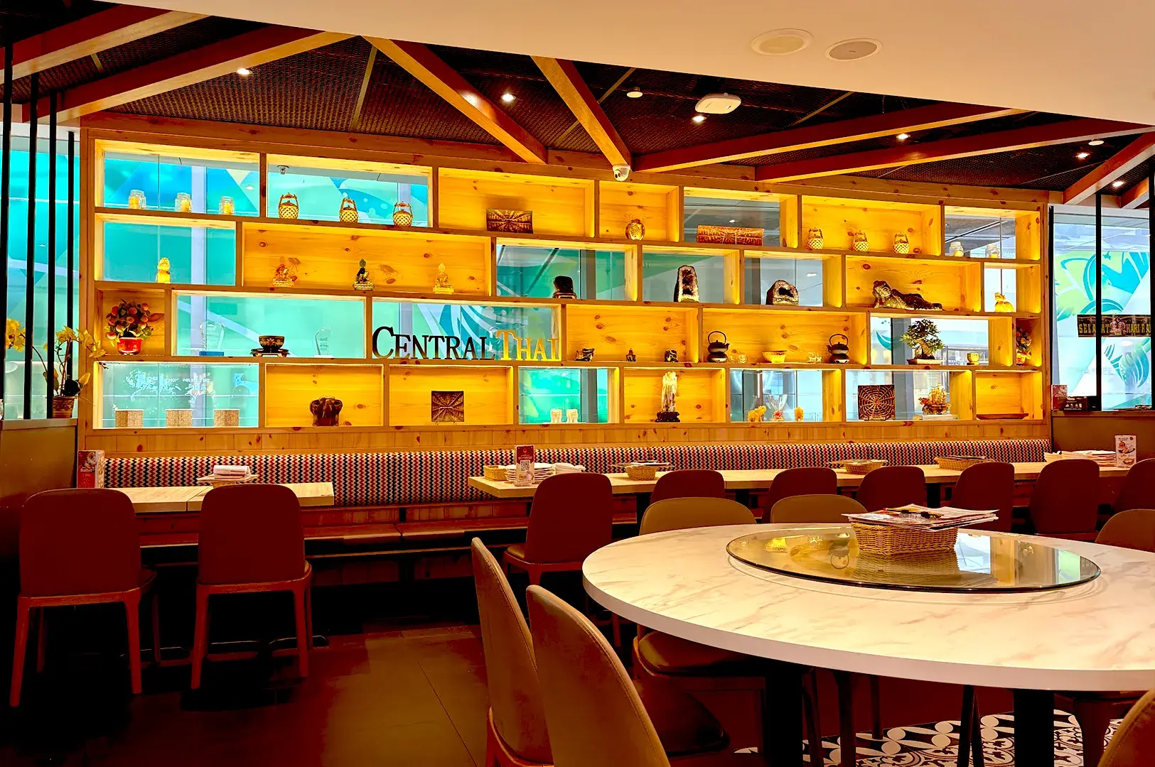 Warm, inviting interior design with decorative wooden shelves at Central Thai, located at Changi Airport for convenient halal-certified Thai cuisine.