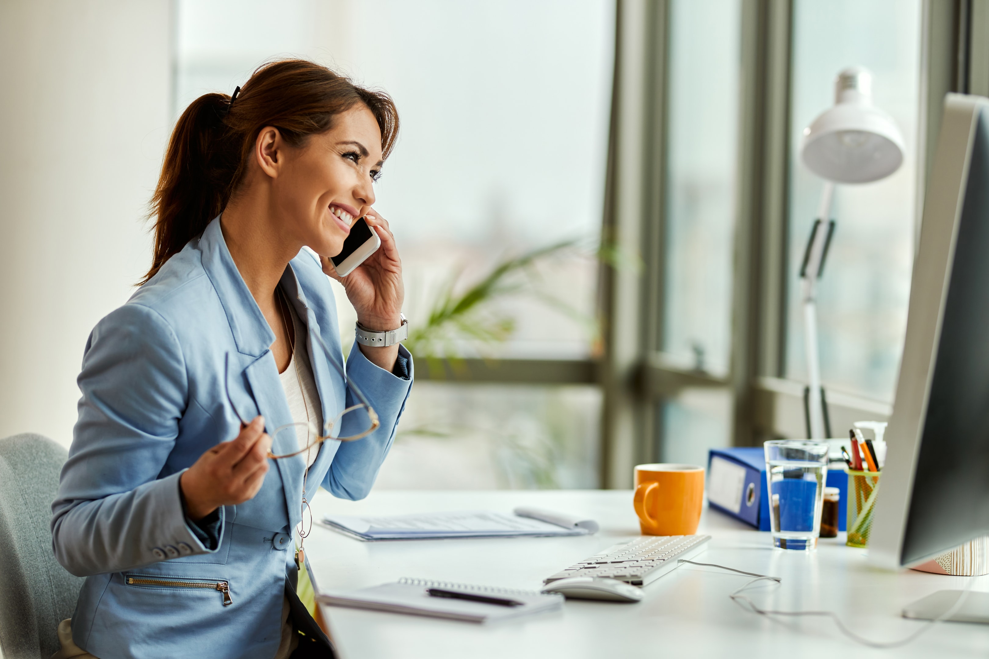 Businesswoman making a call from her desk.