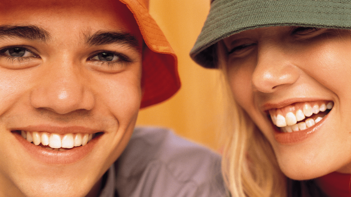 a man and a woman wearing hats smiling