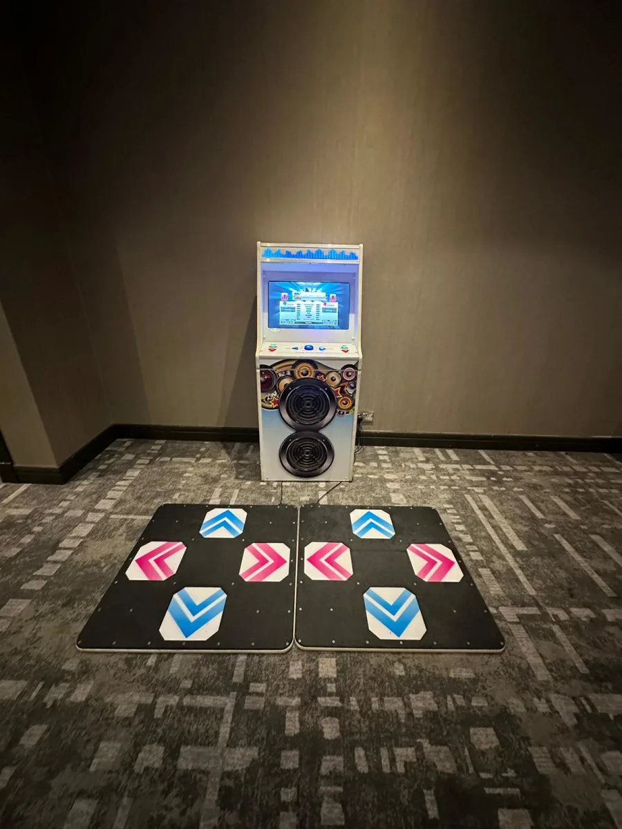 A group of people playing a multiplayer dance machine game in a competition