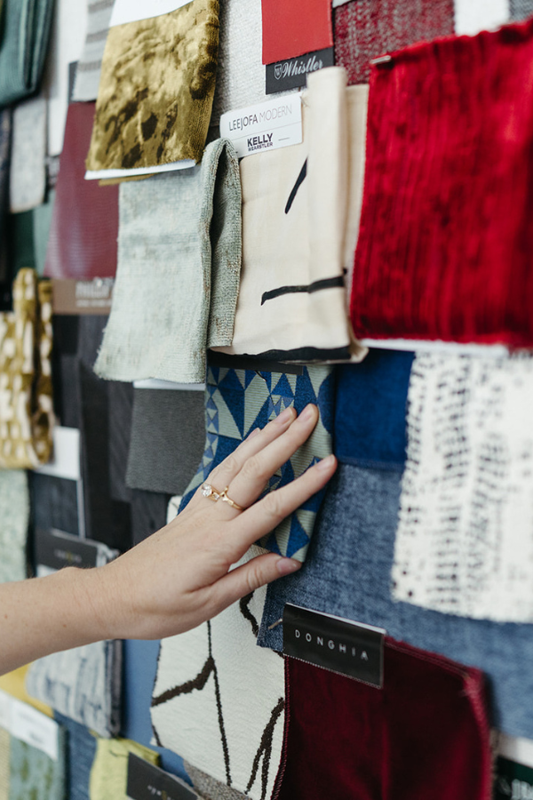 a woman resting her hand on a mood board of fabrics for residential and hospitality interiors (Europe, Americas, and beyond)