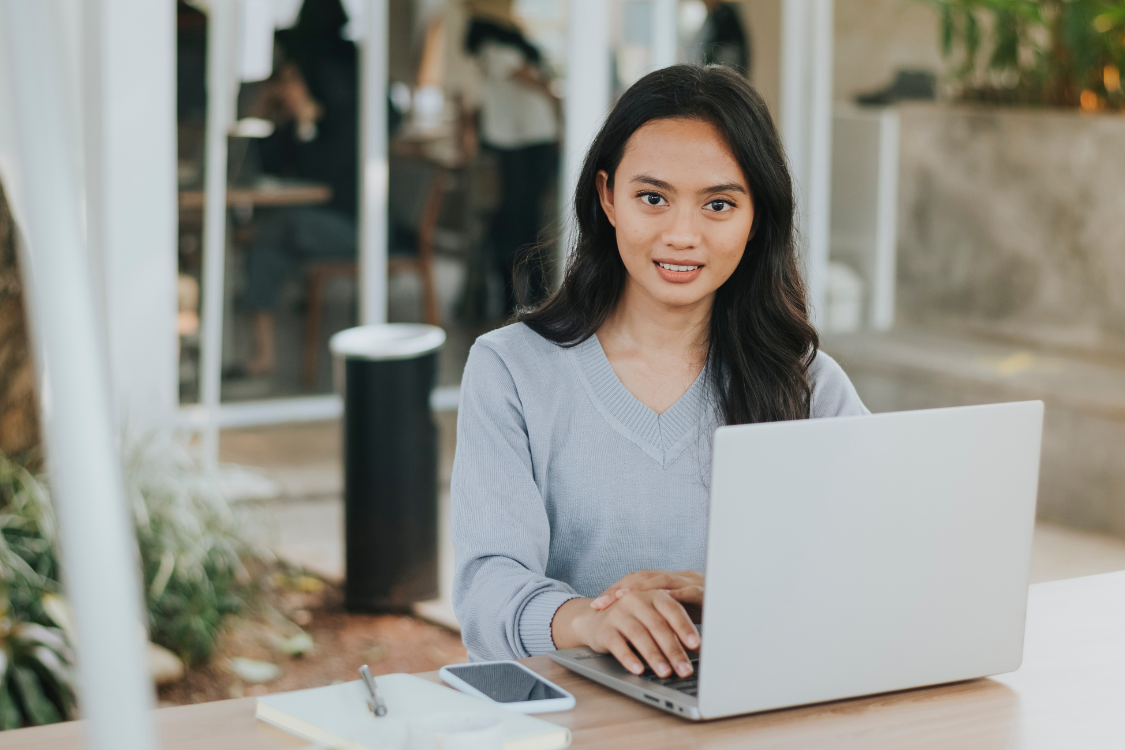 Filipino professional working remotely on a laptop in an outdoor coworking space