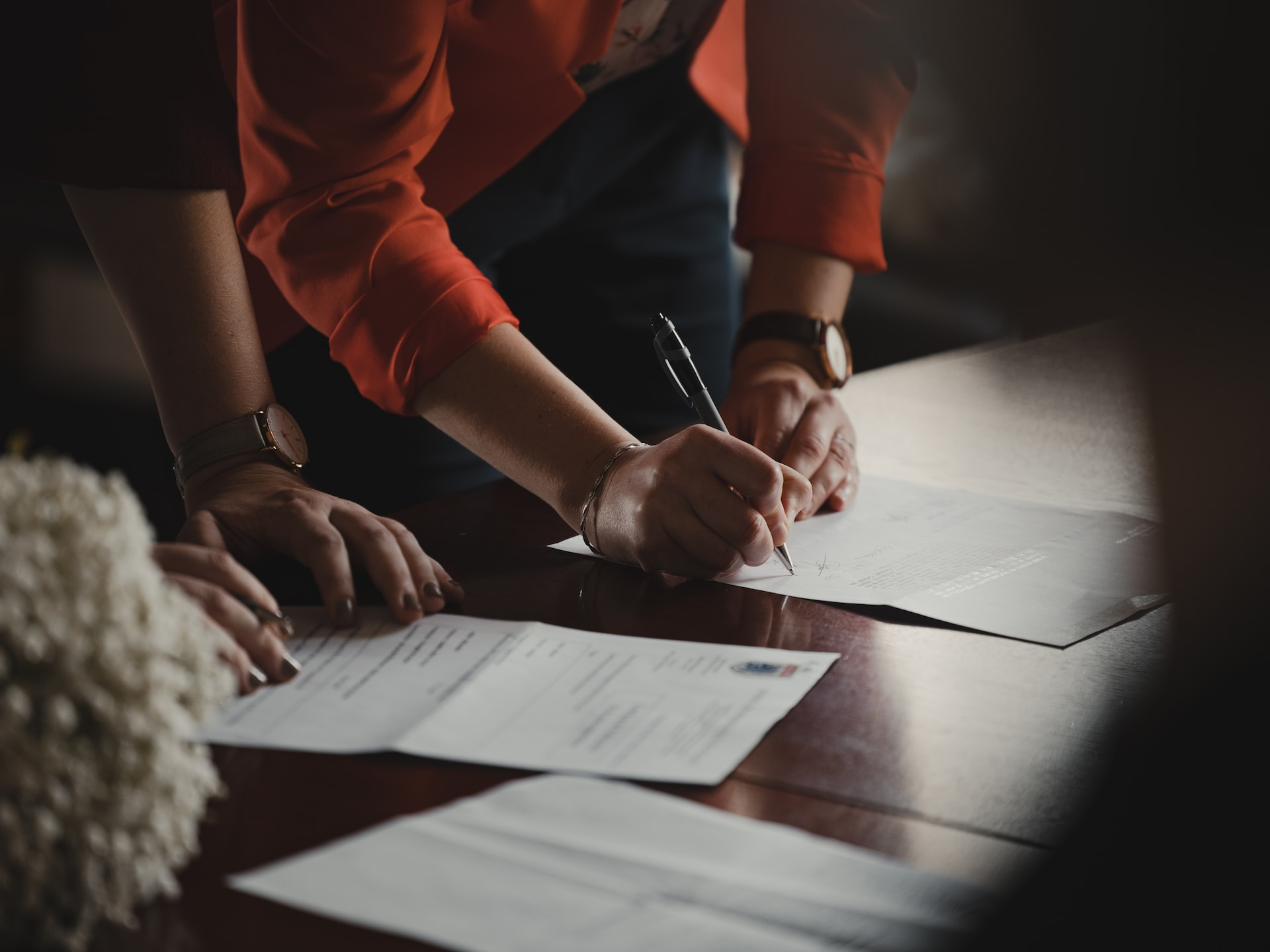 person with long sheet sleeve writing on a paper