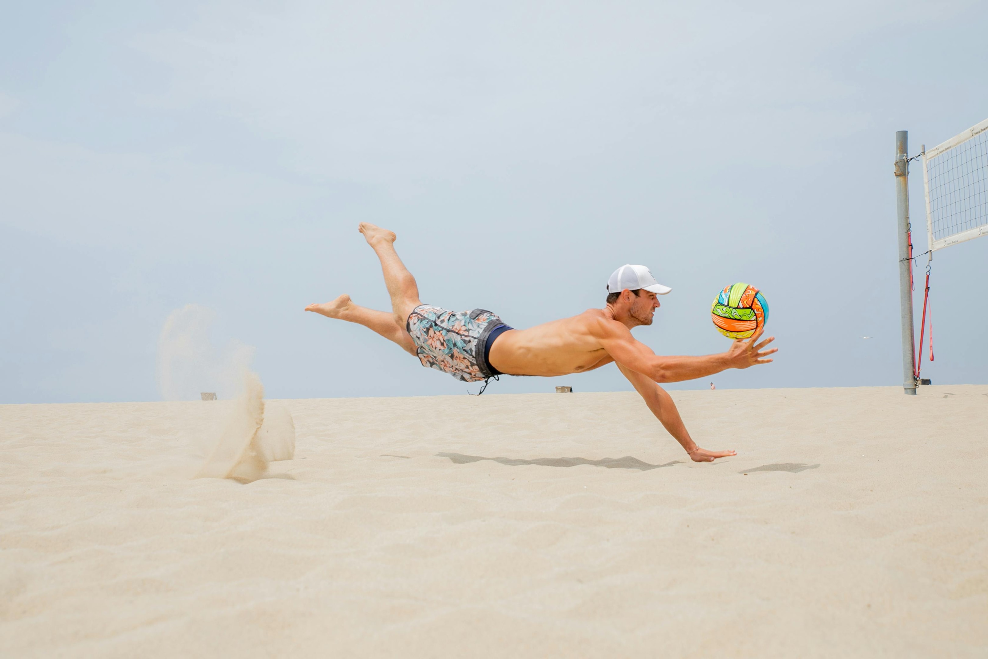 Photo by RDNE Stock project: https://www.pexels.com/photo/man-midair-playing-beach-volleyball-12169037/