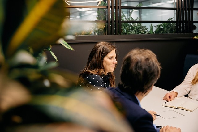 Gespräch über Arbeitszeitverkürzung und Lohnerhöhung zwischen Kollegen im Betrieb.