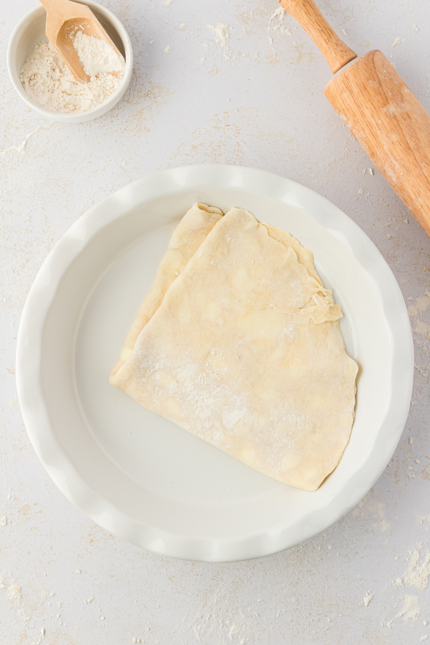 pie dough folded in pie plate