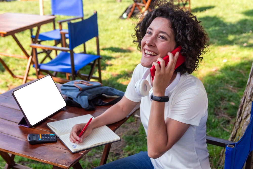Digital nomad working remotely outdoors on a mobile device and making outbound calls.