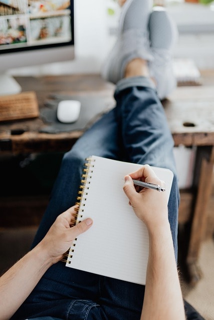 A person writing in a notebook.