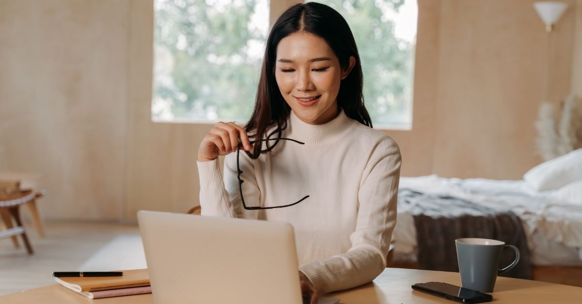 OnlyFans creator working on a laptop to evaluate for tax purposes, organizing self-employment income.