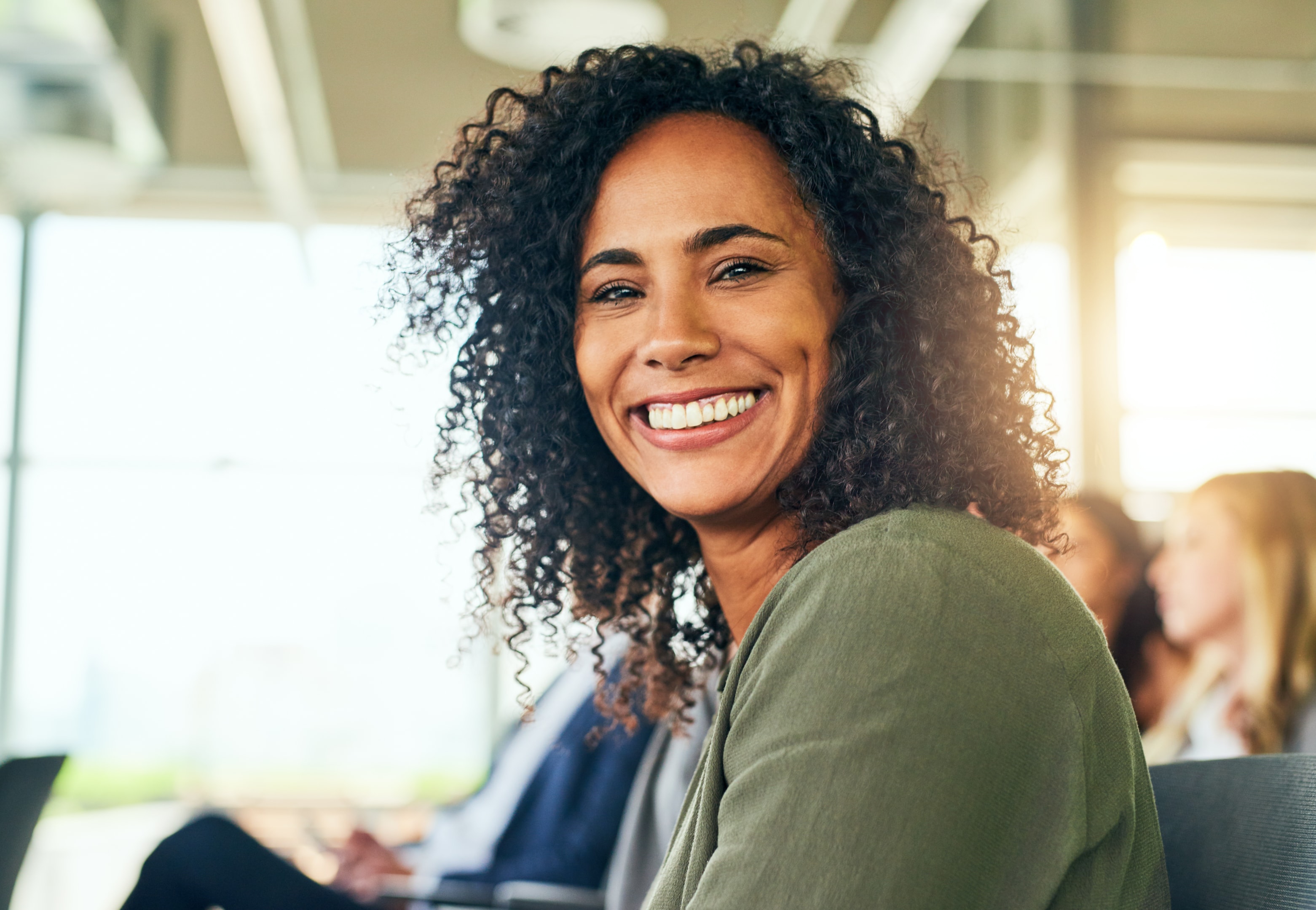 a smiling woman who no longer experiences jaw pain due to tmj treatment to eliminate painful symptoms