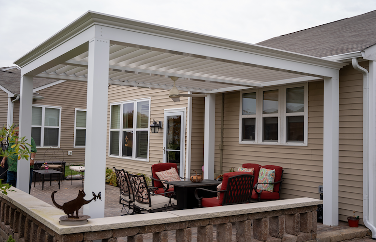 Pictures of red chairs with white pergola on back deck