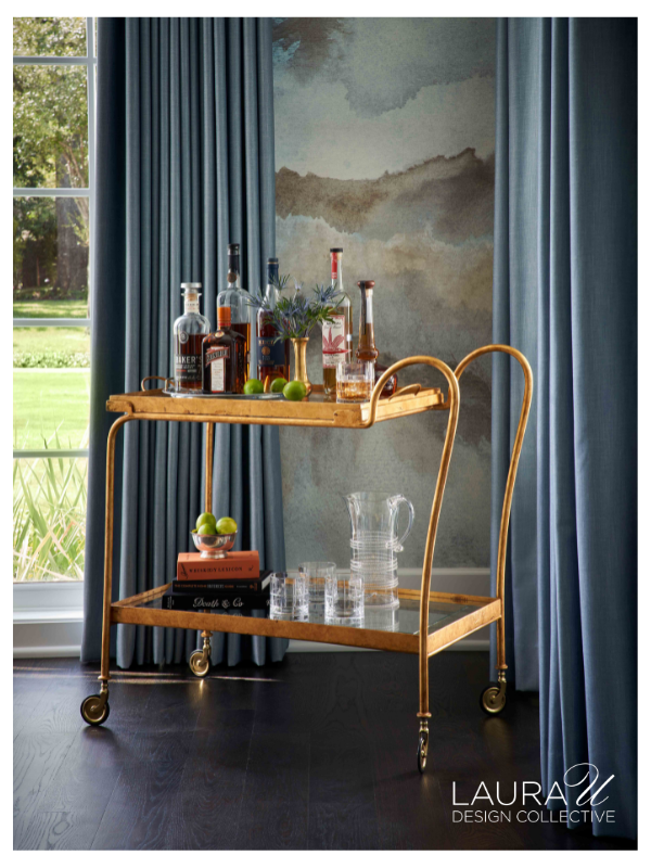 Dining room designed by Laura U Design Collective featuring Phillip Jeffries Beyond wallcovering in Blue Vista on White Paper Weave, blue drapery, gray upholstered dining chairs, black dining table, and a contemporary silver chandelier.