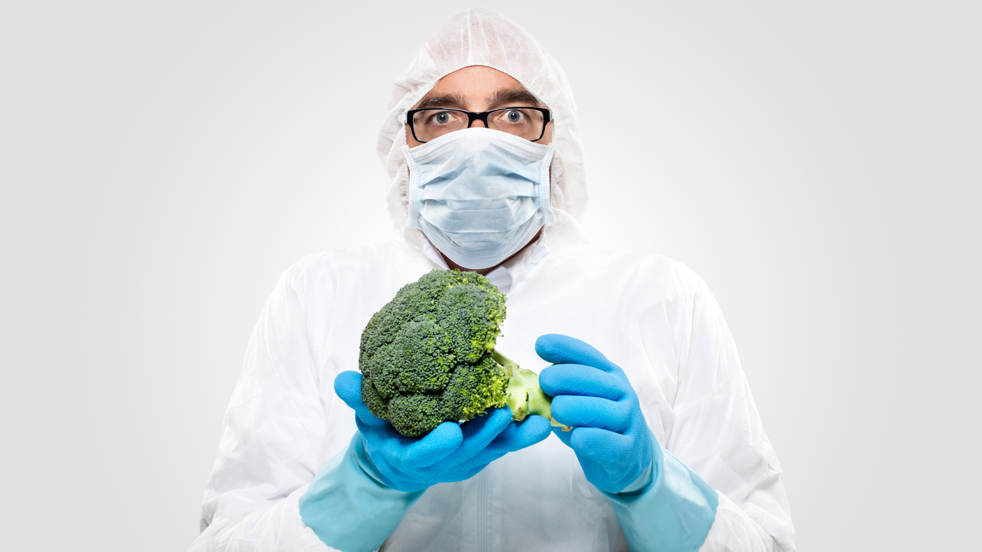 Man in PPE holding a broccoli