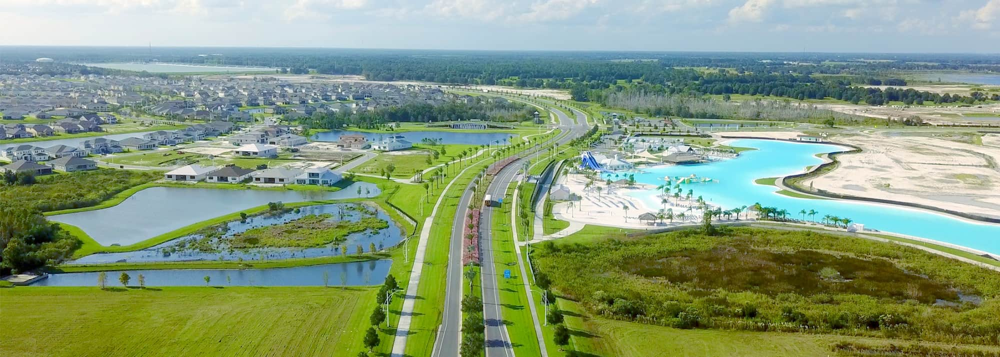 The entrance road to Epperson by MetroPlaces featuring spectacular landscaping, new houses and the first human-made Lagoon in the country.