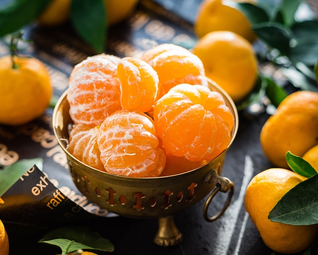 An image of peeled mandarin oranges in a bowl on a table. 
