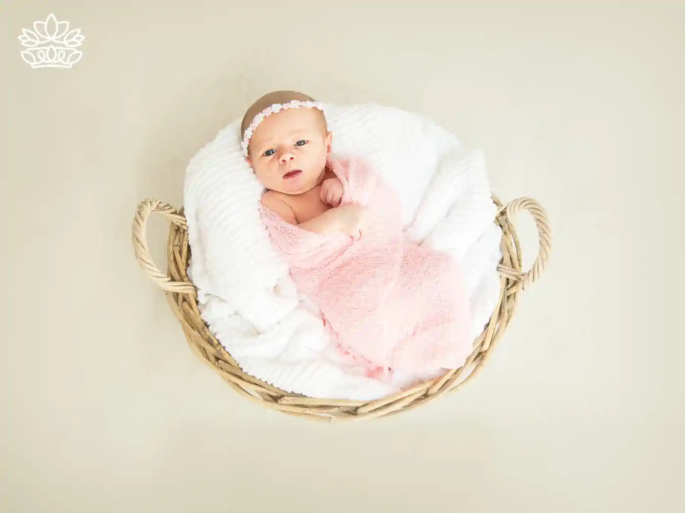 Newborn baby wrapped in a pink blanket in a basket. Fabulous Flowers and Gifts Newborn Baby collection.