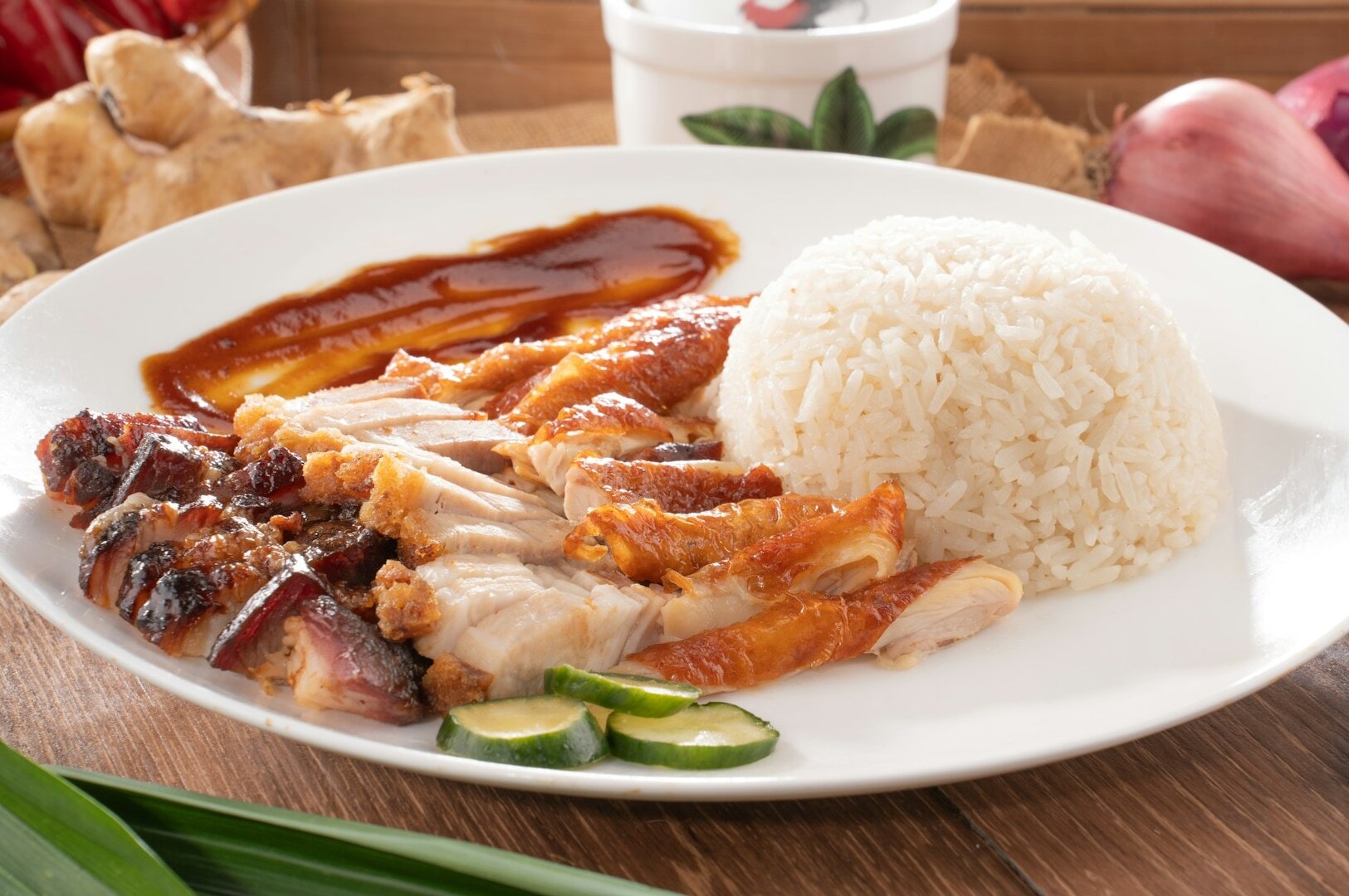 A plate of Hainanese chicken rice featuring tender chicken, fragrant rice, and garnishes.