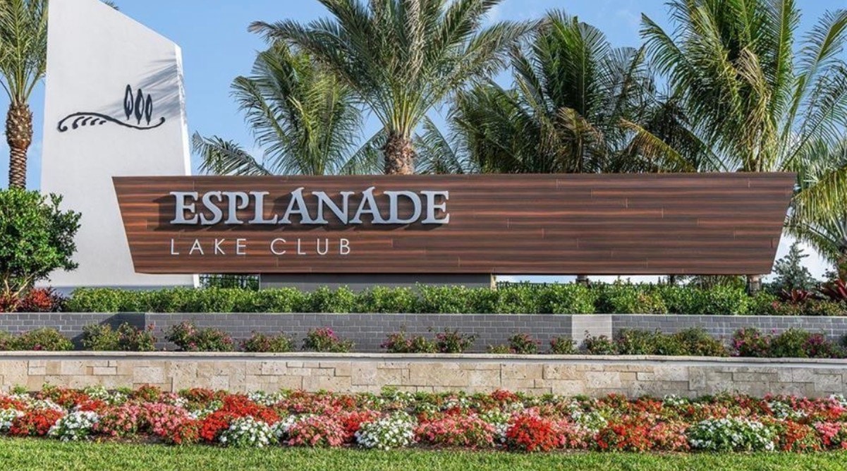 The image depicts an elegant single-family home featuring a beautifully landscaped front yard and a stylish tile roof, embodying the charm of Esplanade Lake Club in Fort Myers, Florida. This inviting exterior reflects the active lifestyle and resort-style amenities available in the community, perfect for those seeking their dream home in Southwest Florida.