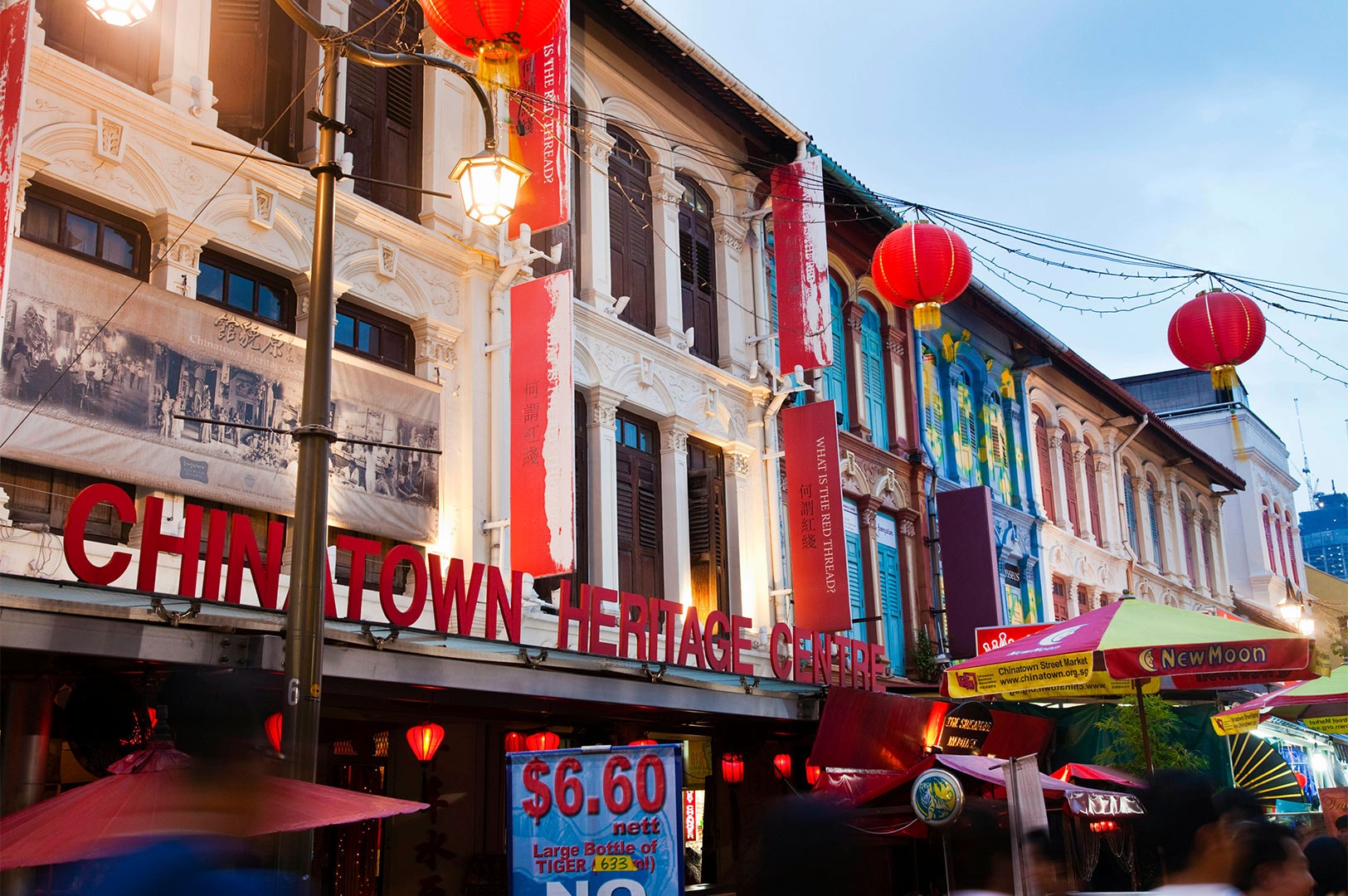 Exterior of the Chinatown Heritage Centre in Singapore at dusk, featuring traditional shophouse architecture and red paper lanterns.