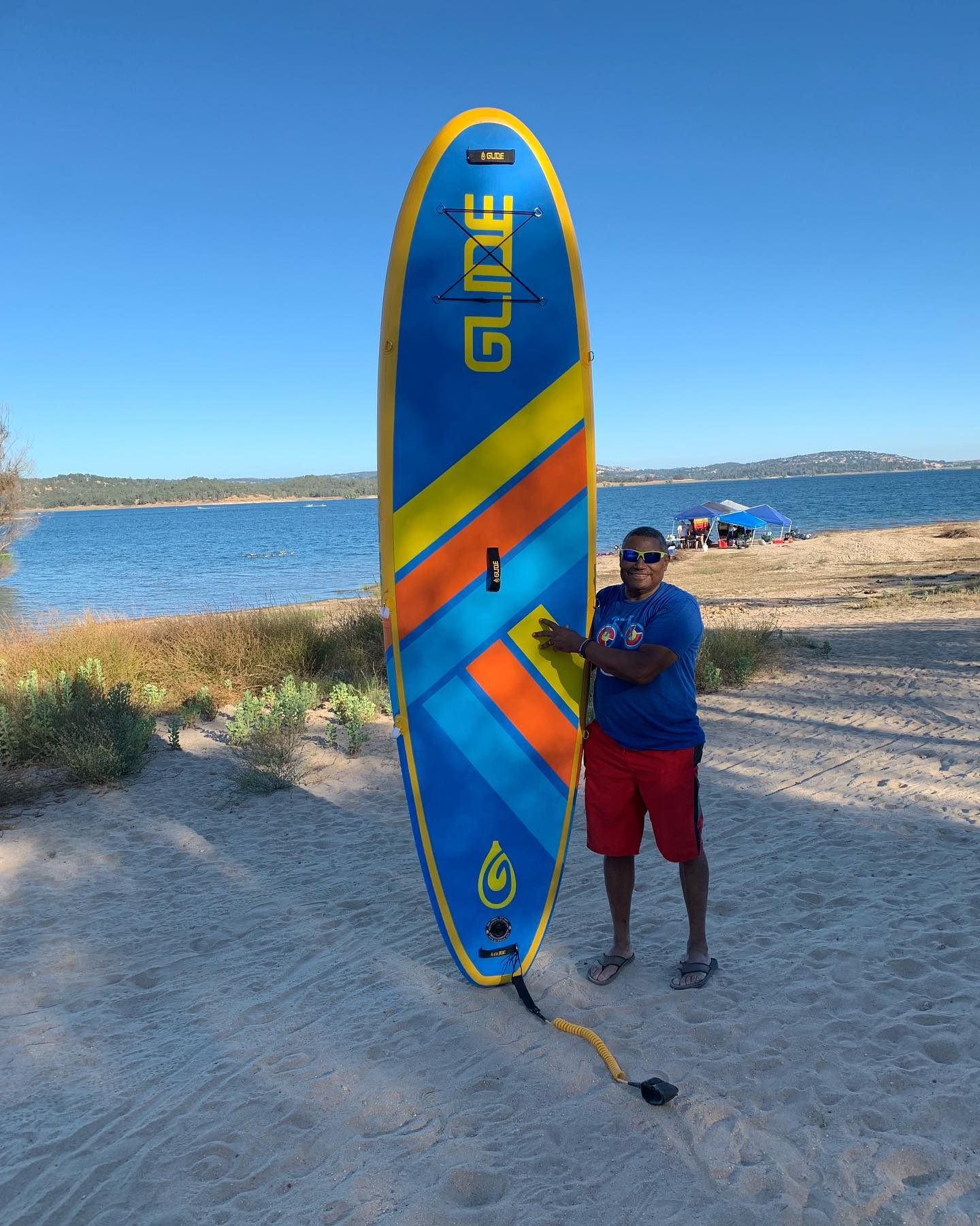 man holding an inflatable stand up paddleboard