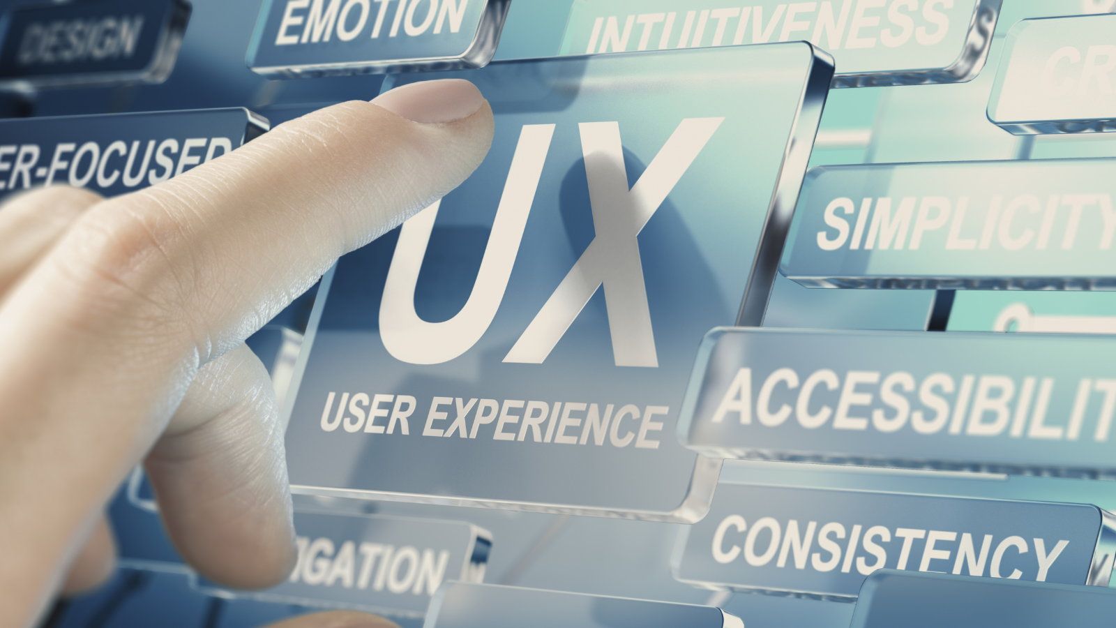 Finger pressing a UX “User Experience” key among keywords like simplicity and consistency