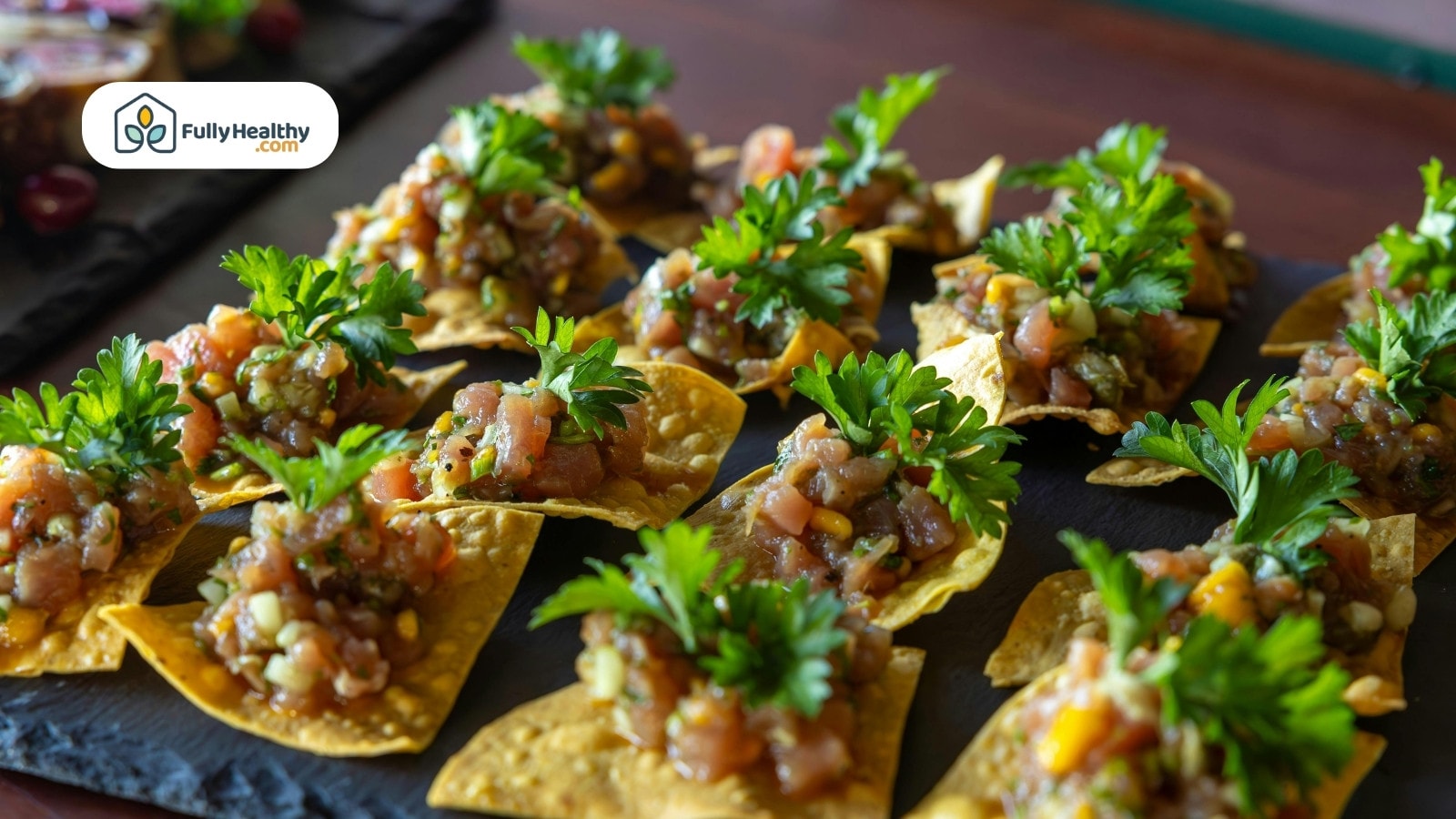Tortilla chips topped with salsa and fresh parsley garnishes.