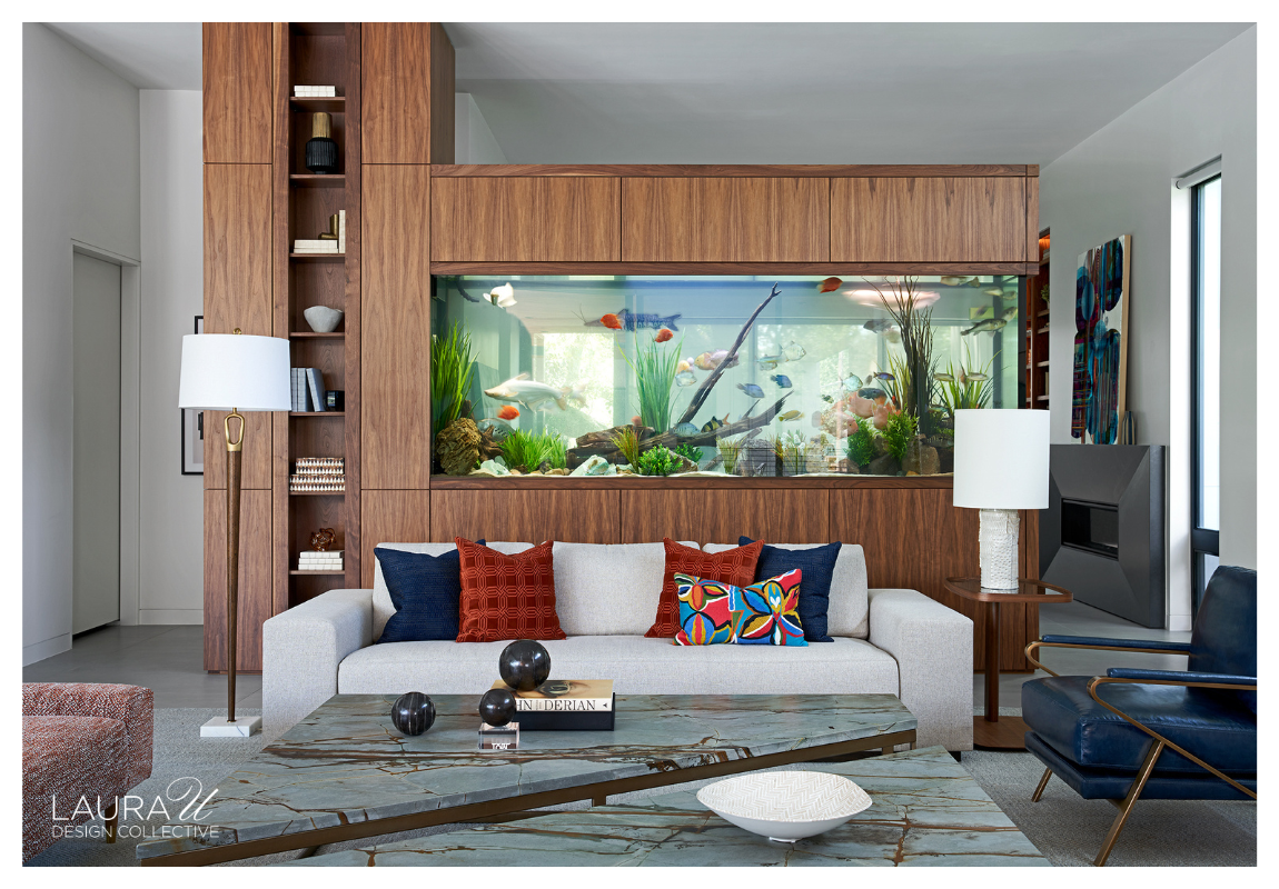 Walnut built-in cabinetry framing a large aquarium that divides two living spaces.