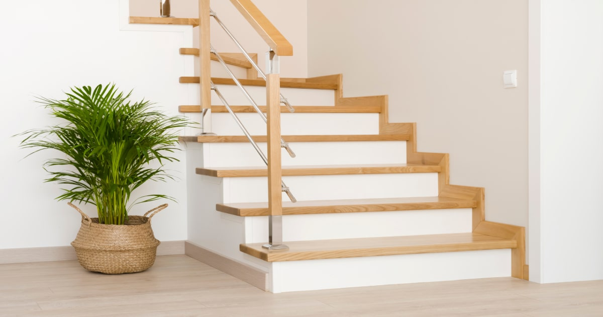 Een Z-trap met beige treden en witte stootborden zorgt voor een moderne look.