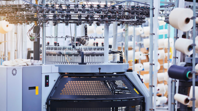 An image of a machine in a factory with lots of yarn