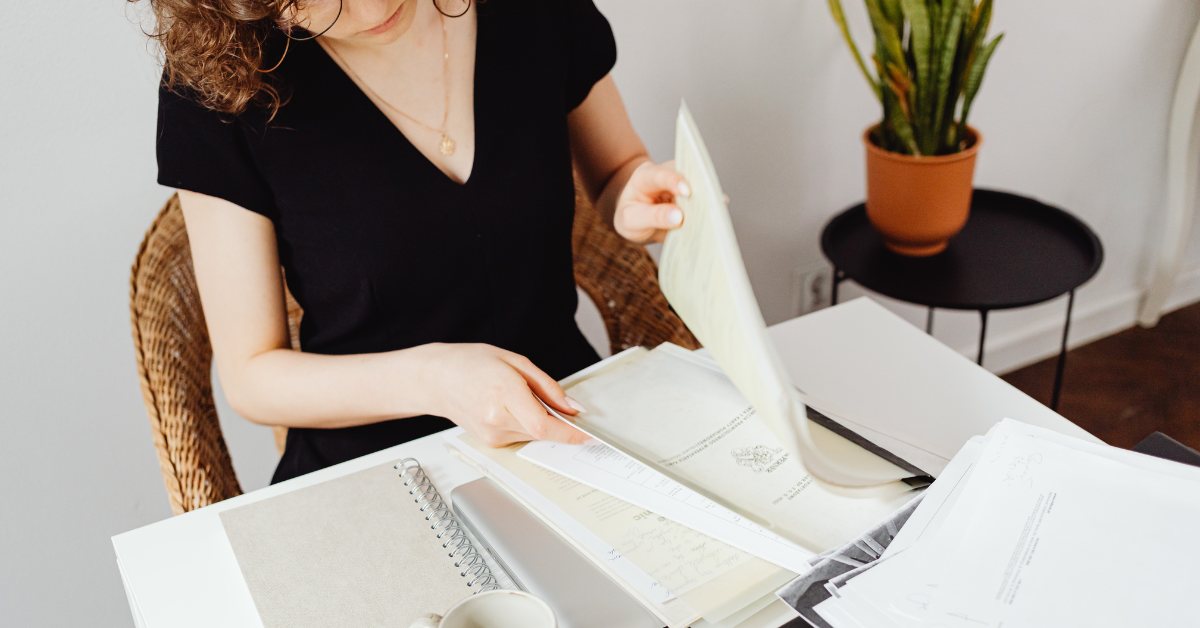 Woman organizing papers, wondering "how long do I need to keep income tax records?"