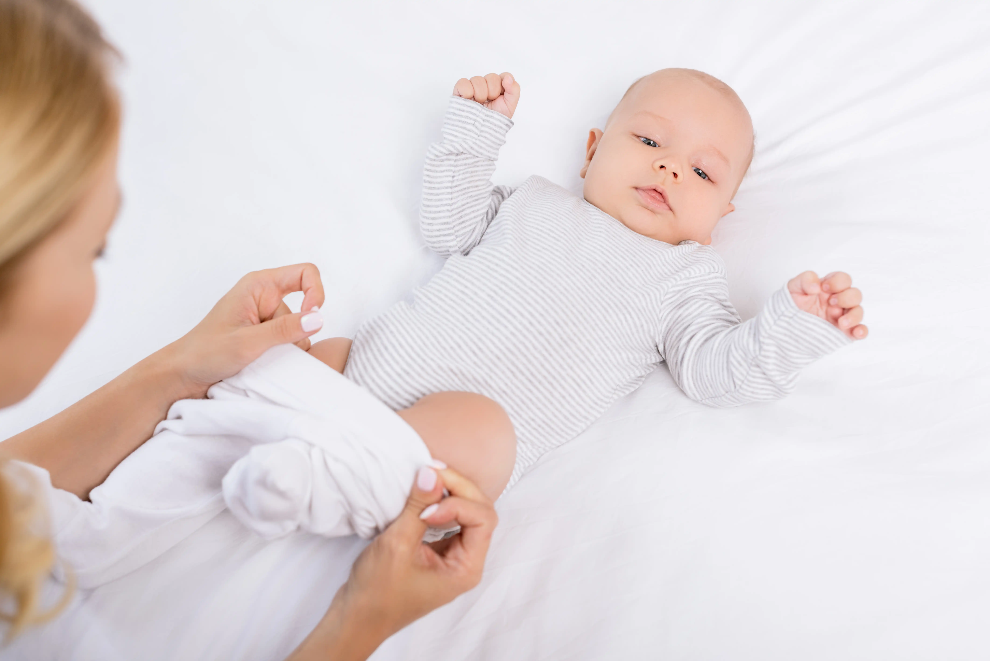 women dressing baby carefully