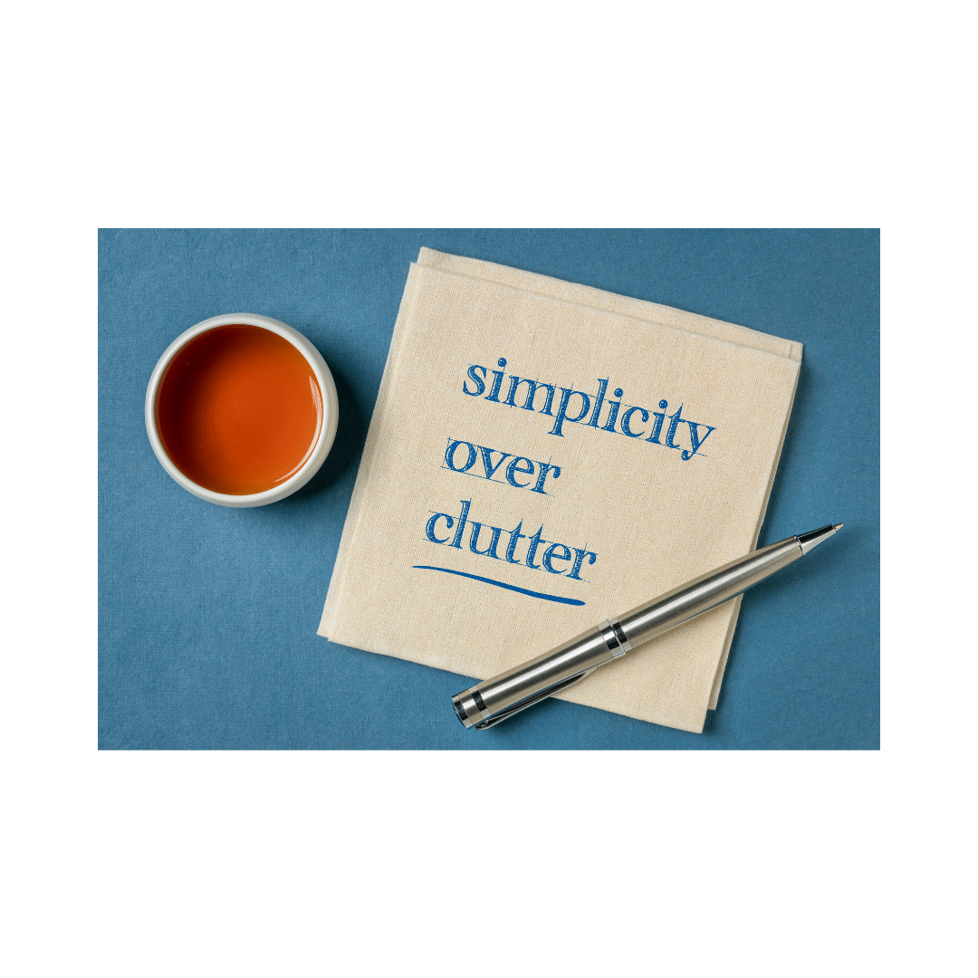 a napkin with " simplicity over clutter " written on it. a pen sits over the bottom part of the napkin
