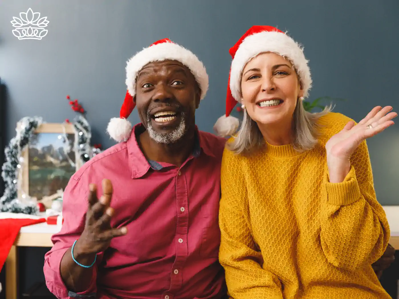 A joyful couple in Santa hats, surrounded by festive decorations, sharing holiday cheer. Part of the Festive Season Flowers Collection. Delivered with Heart by Fabulous Flowers and Gifts.