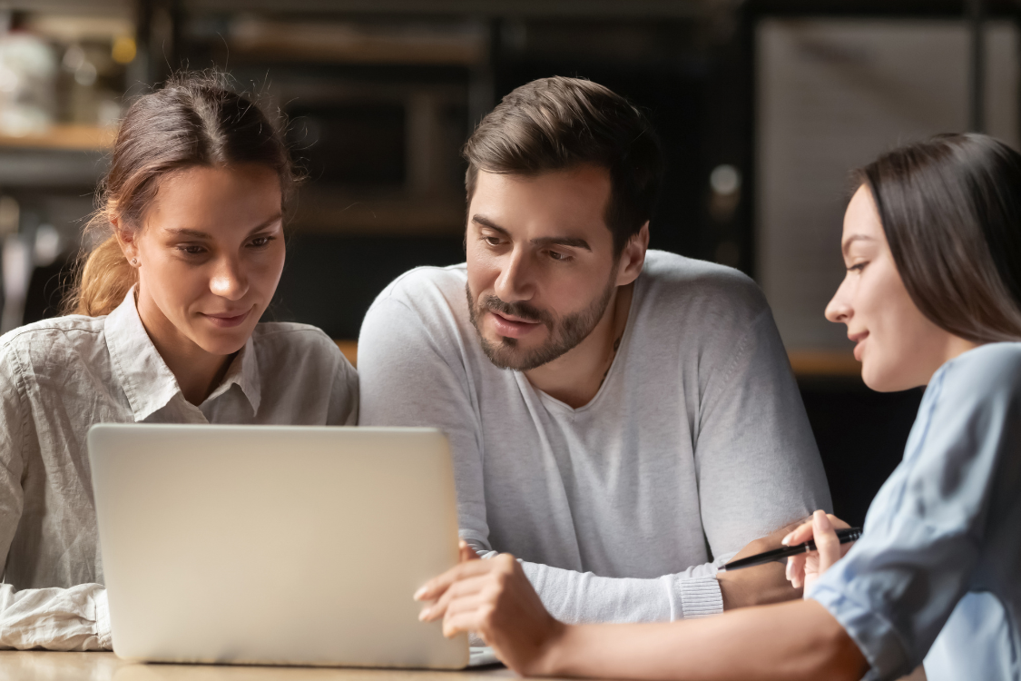 Clients reviewing marketing materials on a laptop before listing their business for sale