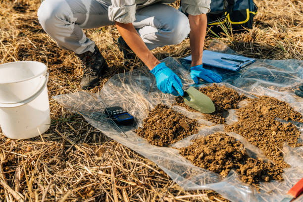 A picture of a farmer using soil testing equipment in a field