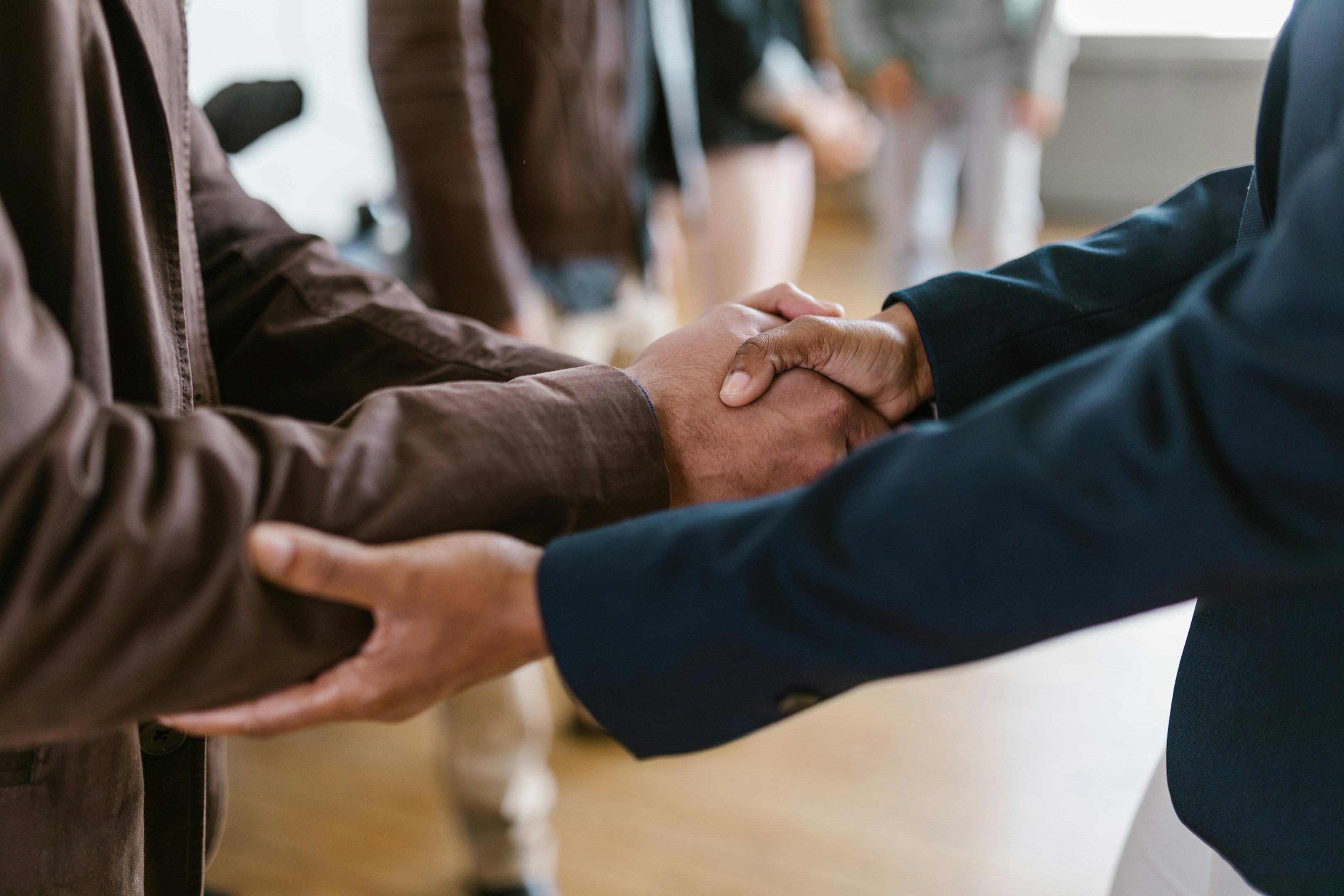 Handshake between real estate investors at networking event. 