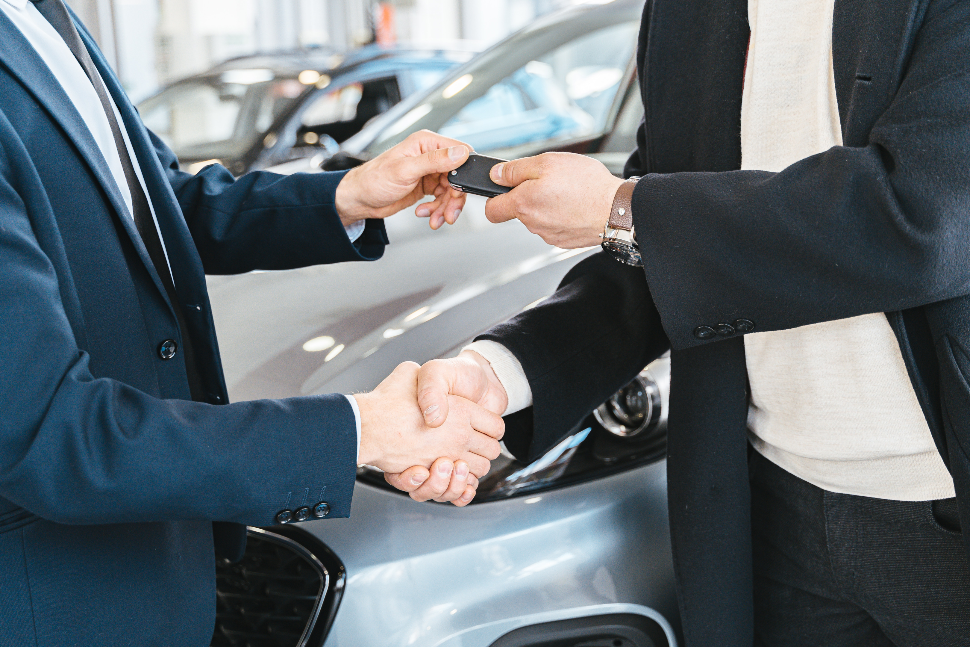 Shaking hands and exchanging car keys after used car sale