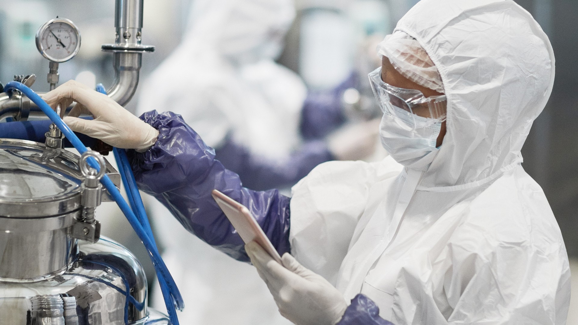 A chemical worker inspects chemicals in a production facility.