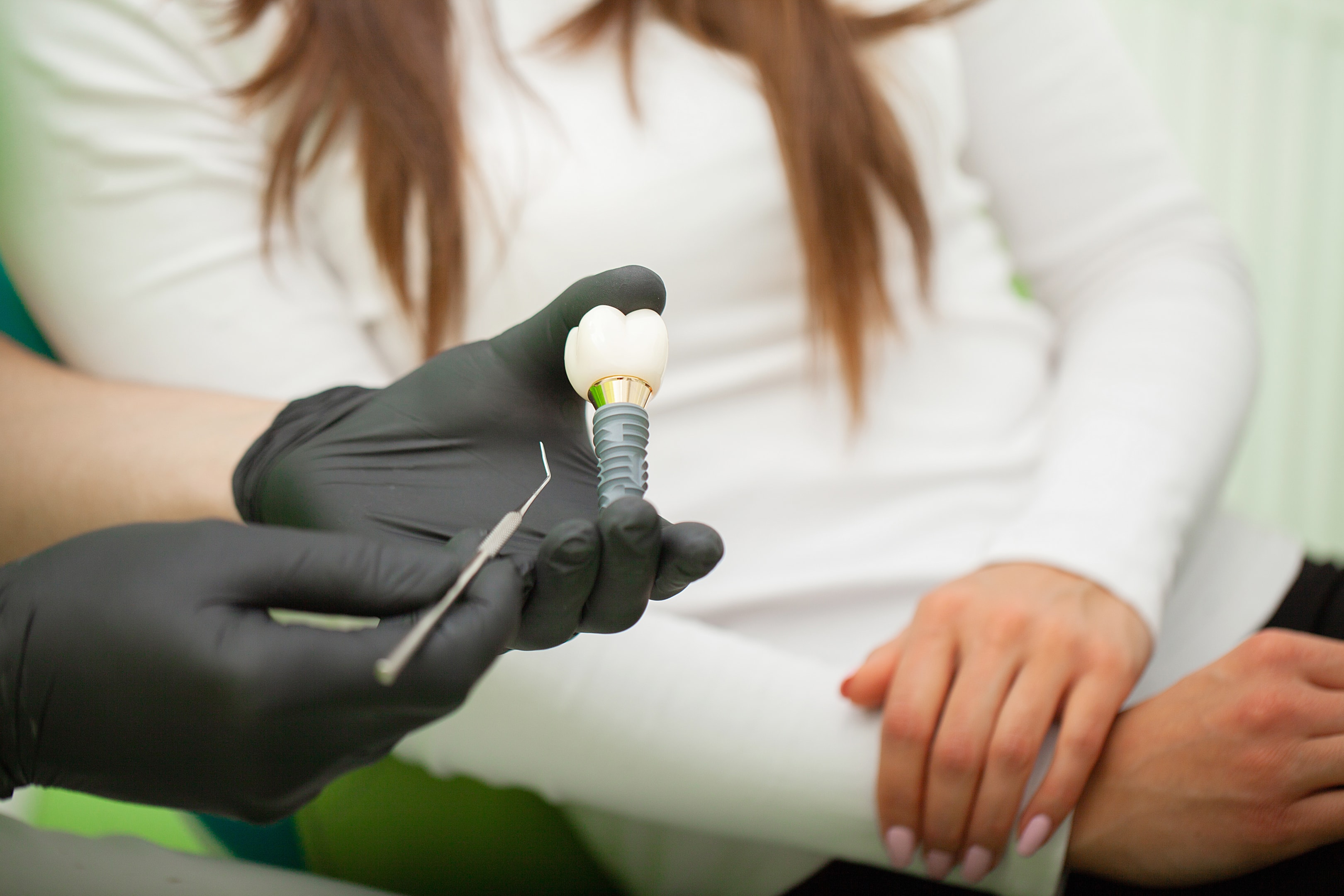 surgeon telling patient more in depth about what a dental implant is for