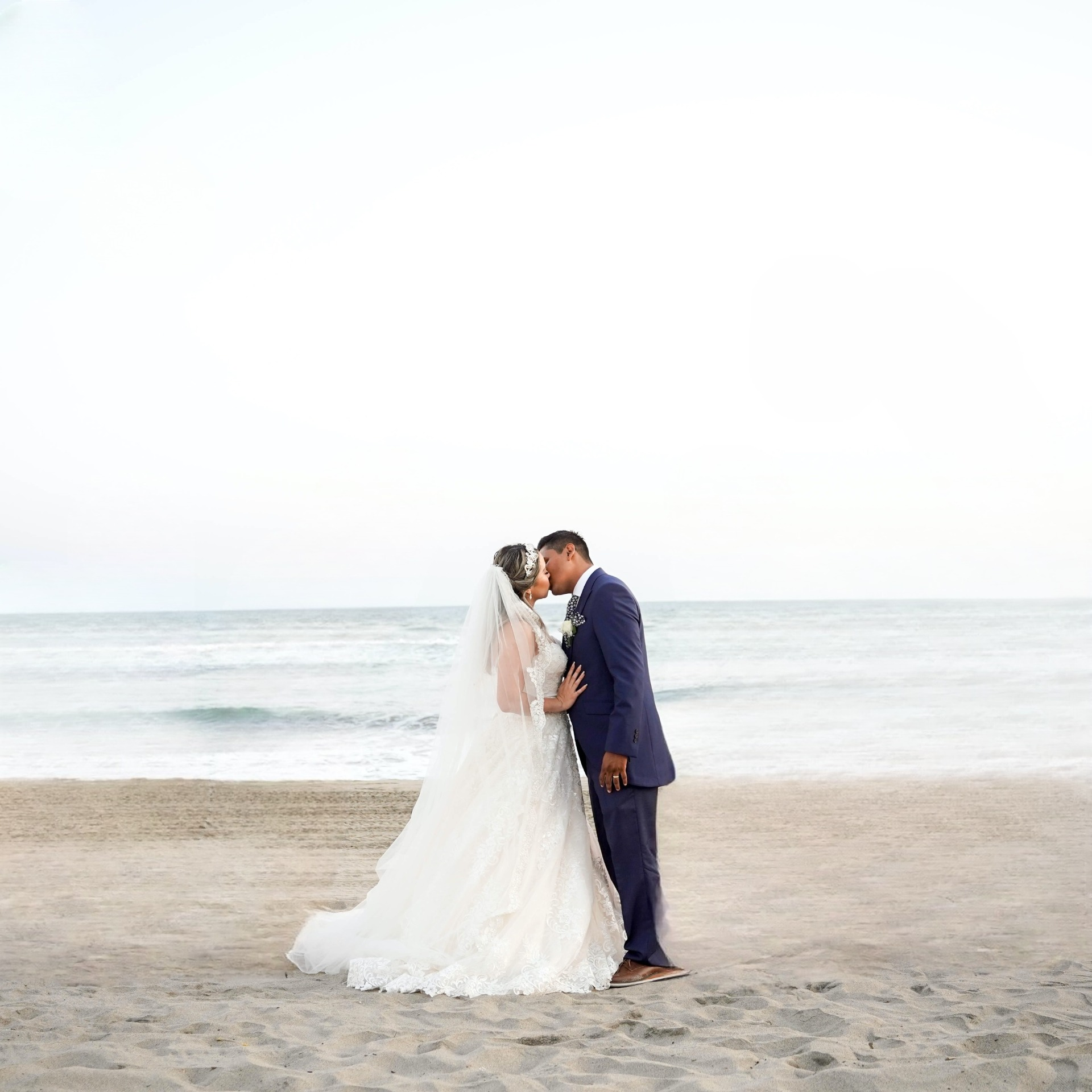 Image of the bride and groom on the beach, but the people are removed.
