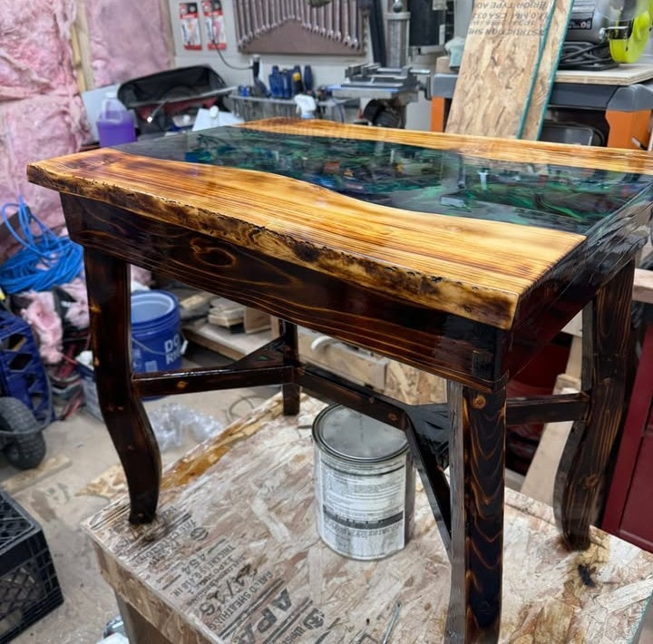 An epoxy resin table, where John used a heat gun to remove bubbles from the surface and then sanded it to a mirror sheen.