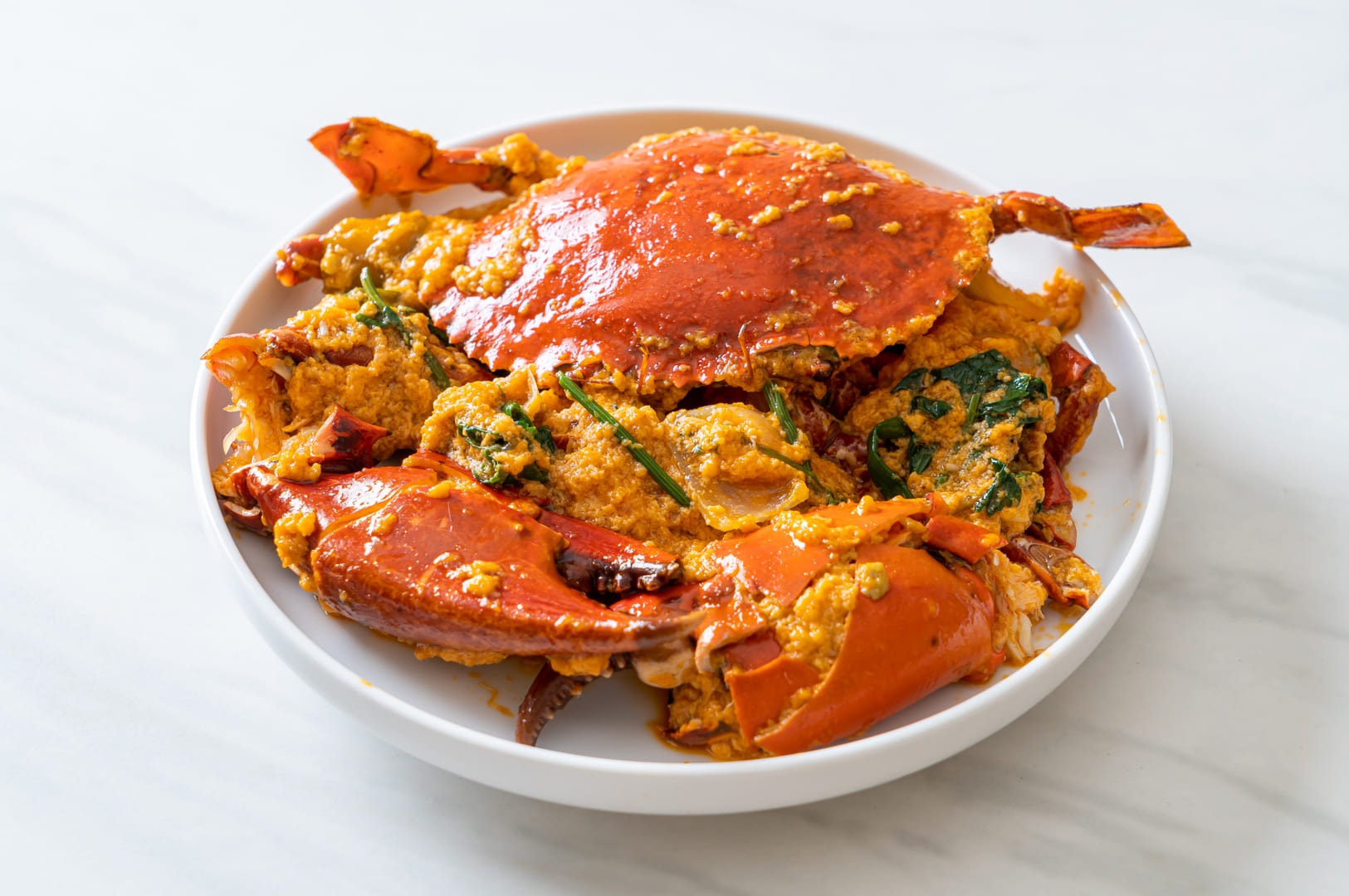 A white bowl brimming with succulent crab meat, ready for a flavorful Chili Crab dish.