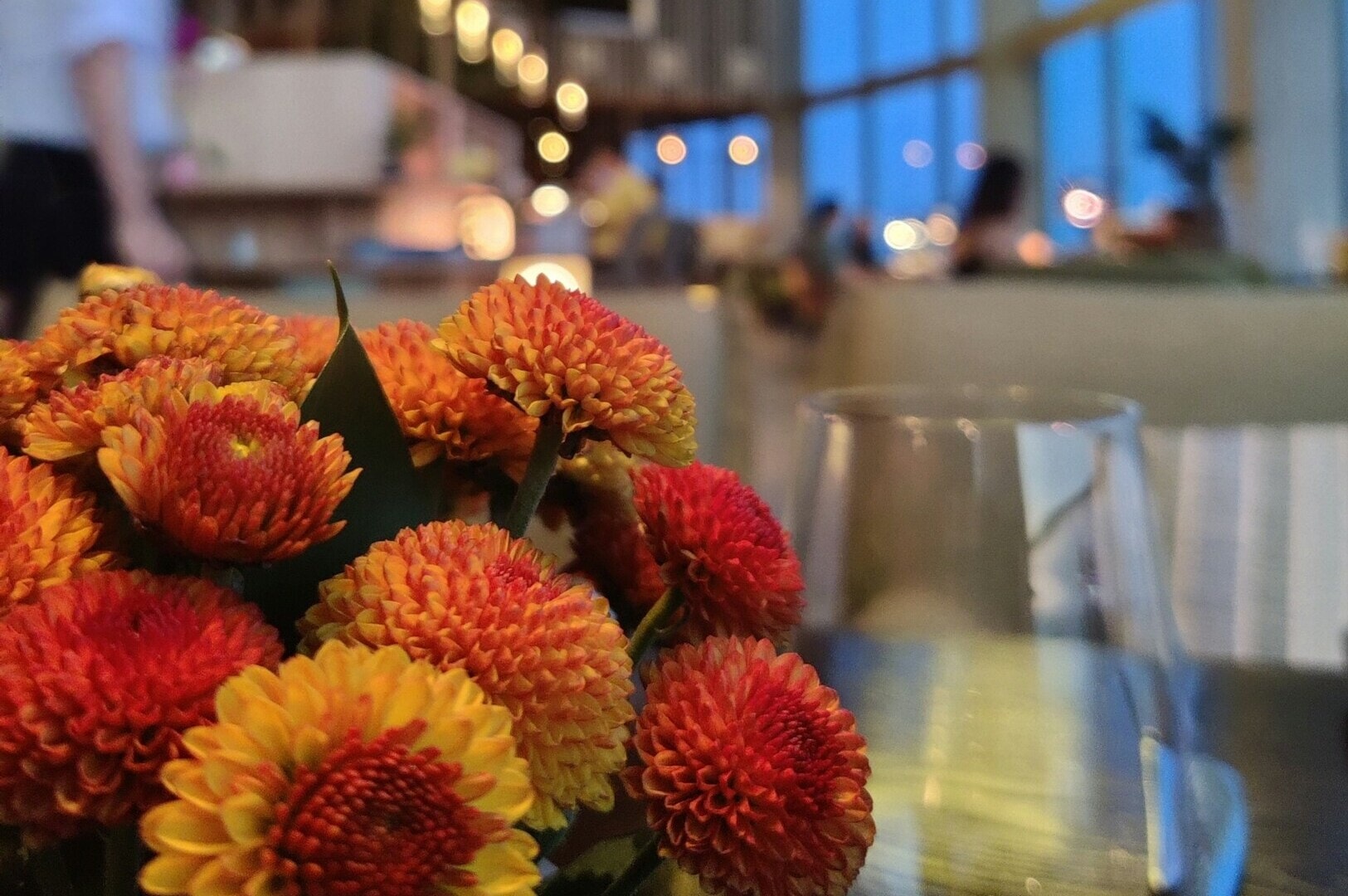 A beautifully arranged vase of flowers sits on a table in a Singapore restaurant, enhancing the elegant dining experience.