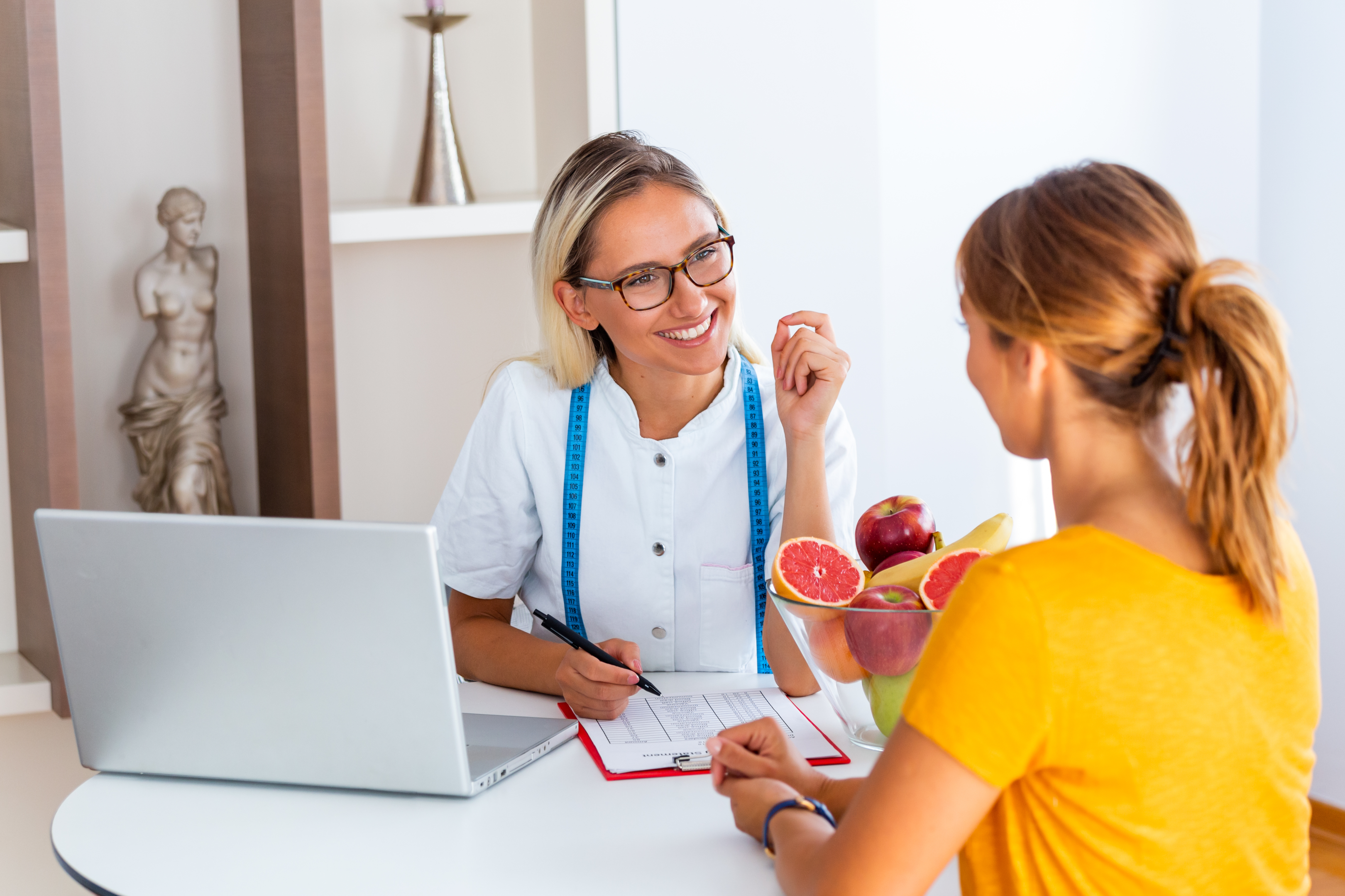 Female nutritionist guiding client by assessing current diet: what do nutritionists do?